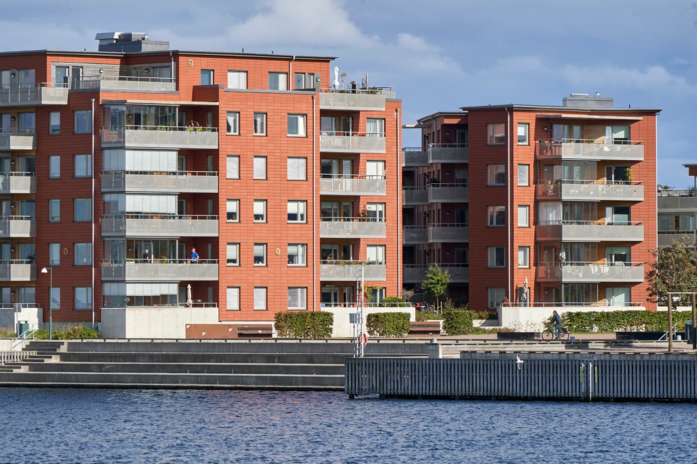 Bostadshus vid vattnet, som speglar BRF24 stöd till bostadsrättsföreningar – Om oss.